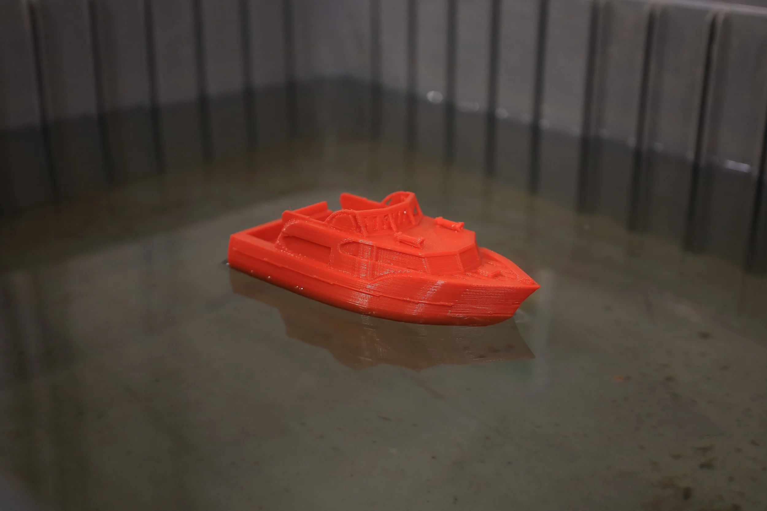 Student holding a small 3D-printed boat